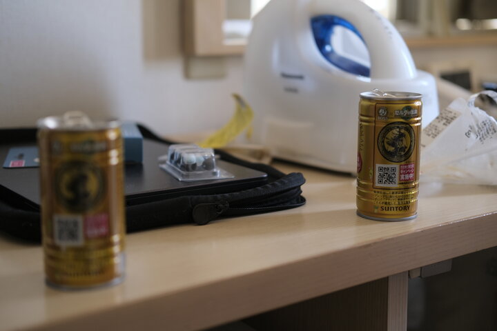 Two canned coffees on a messy desk